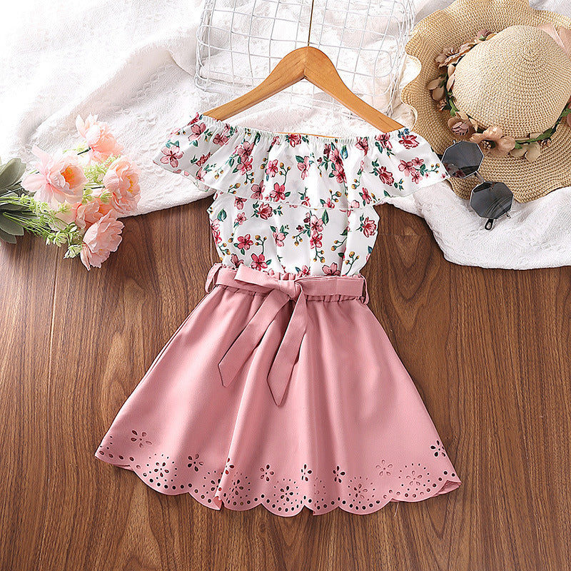 Blusa blanca floreado y pollera rosa con cinto