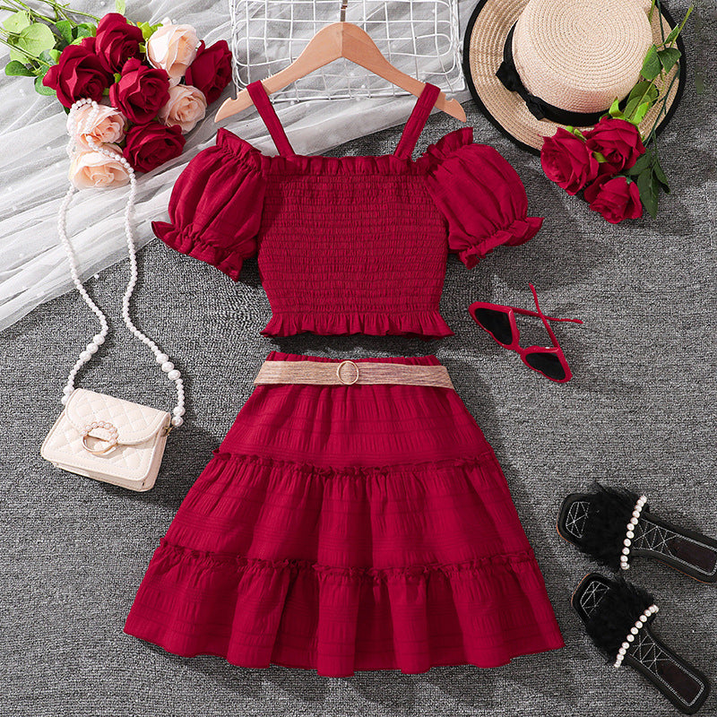 Blusa bordo engomado con hombros rectos y pollera  con cinto