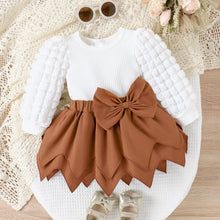 Cargar imagen en el visor de la galería, Blusa blanca con mangas abullonadas y pollera marrón escalonado con moño
