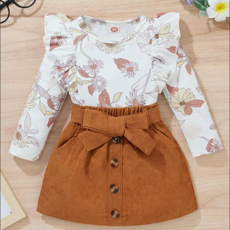 Blusa blanca floreado con volados y pollera corderoy marrón con cinto