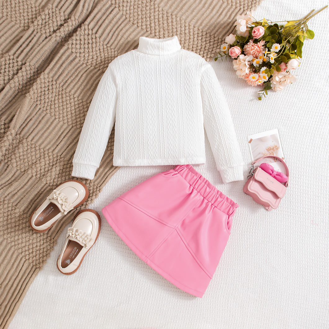 Blusa blanca con relieve y pollera de cuerina rosa