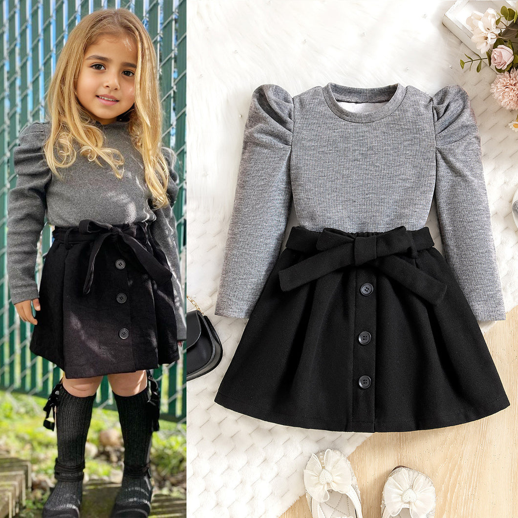 Blusa gris manga abullonada y pollera negra con cinto