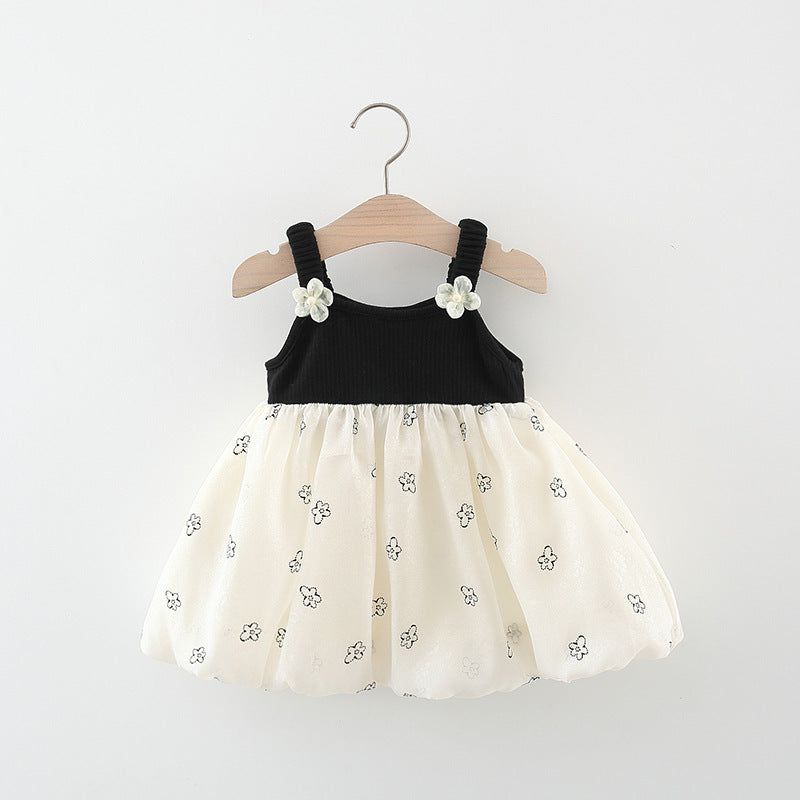 Vestido negro, falda crema con detalles de flores y moño