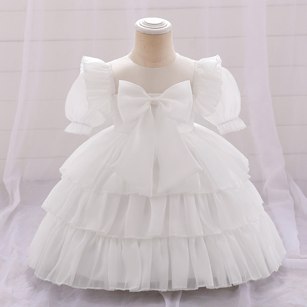 Vestido blanco escalonado con volados y moño