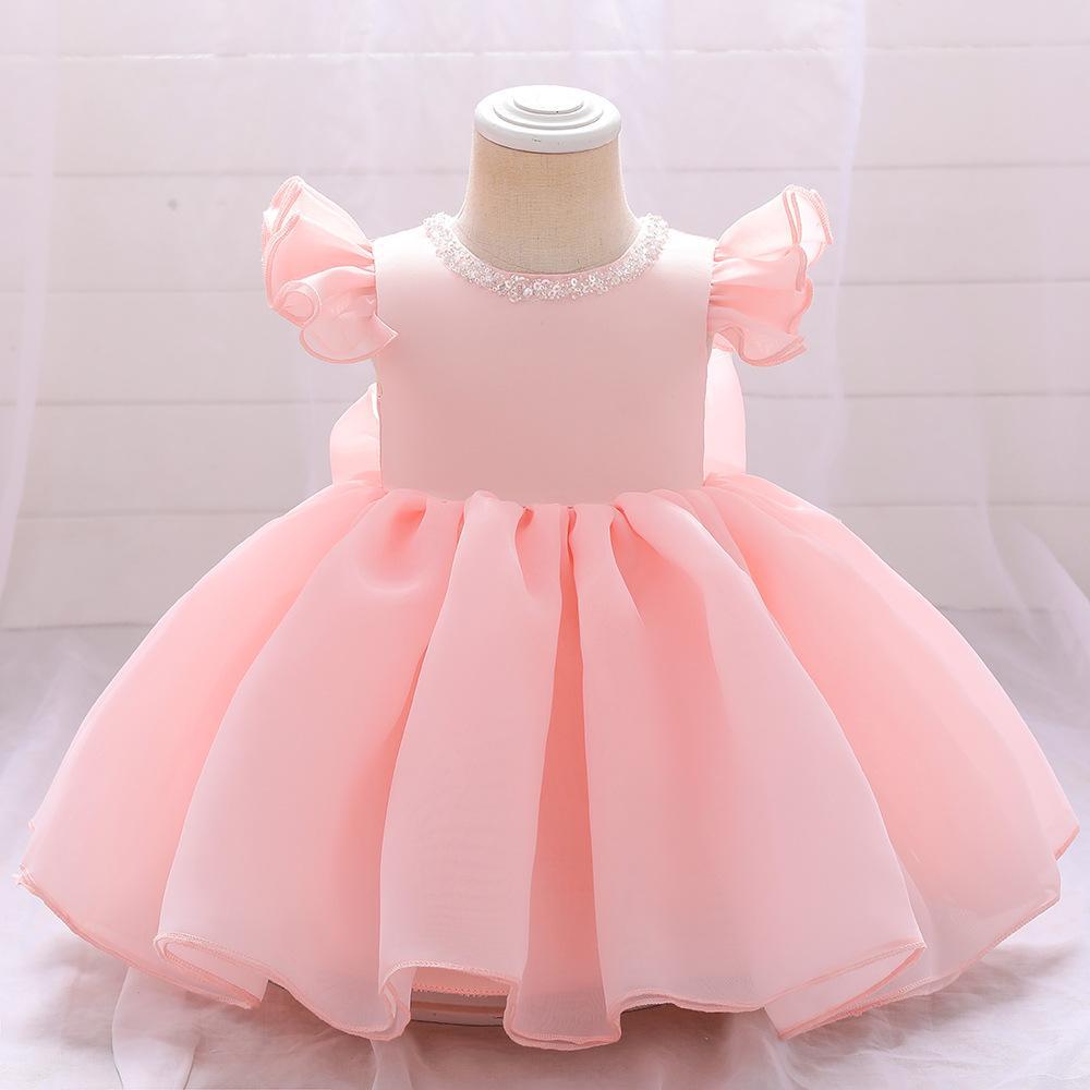 Vestido liso rosa con detalles  de lentejuelas  y moño