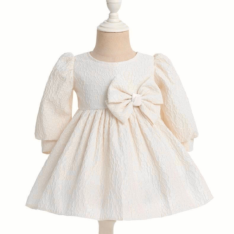 Vestido crema con bordados en dorado y moño