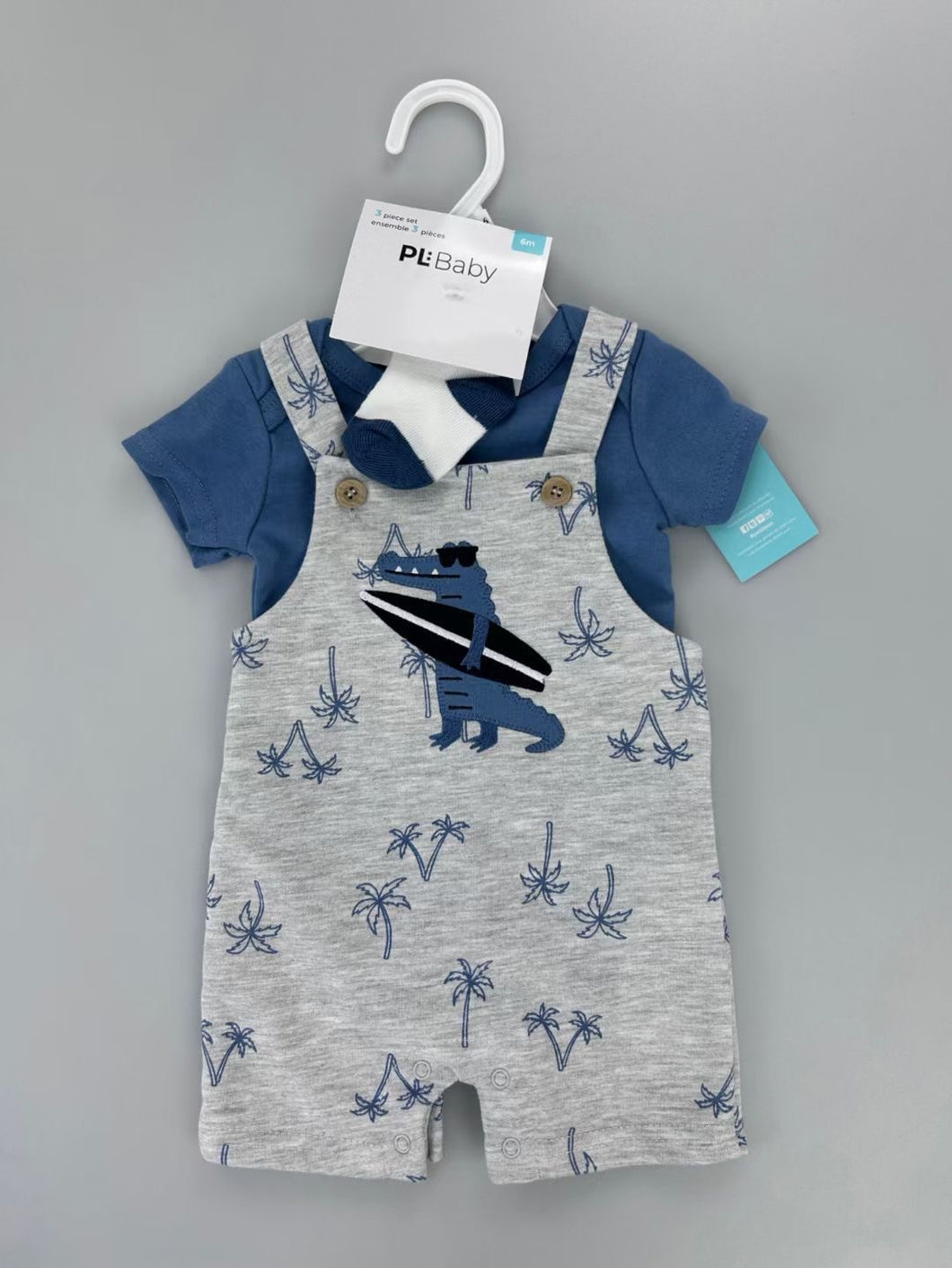 Body azul marino con jardinera gris, estampa de cocodrilo y palmeras, incluye medias