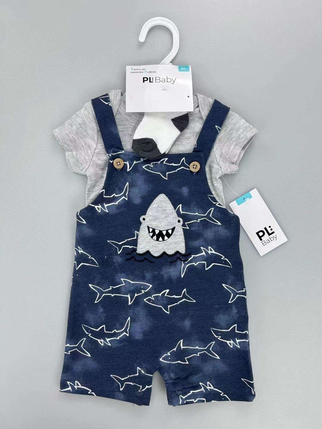 Body gris y jardinera azul marino con estampa de tiburones, incluye medias