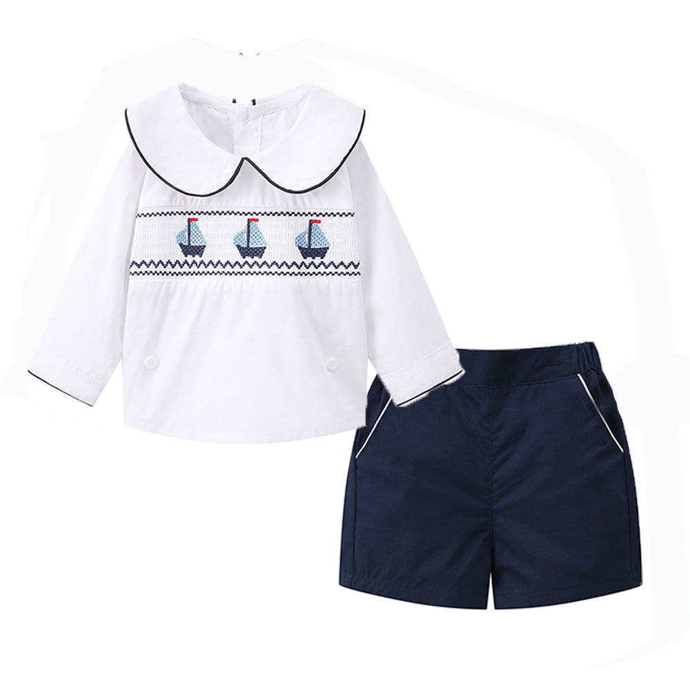 Camisa blanca con bordado de barcos y short azul marino