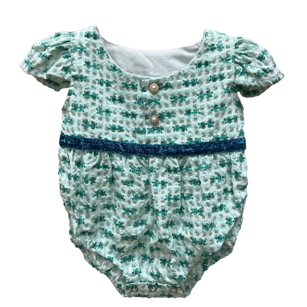 Body verde con estampa de moño y cinta celeste con brillo